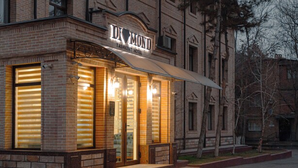 A hotel with a brick facade, large windows, and a prominent awning.