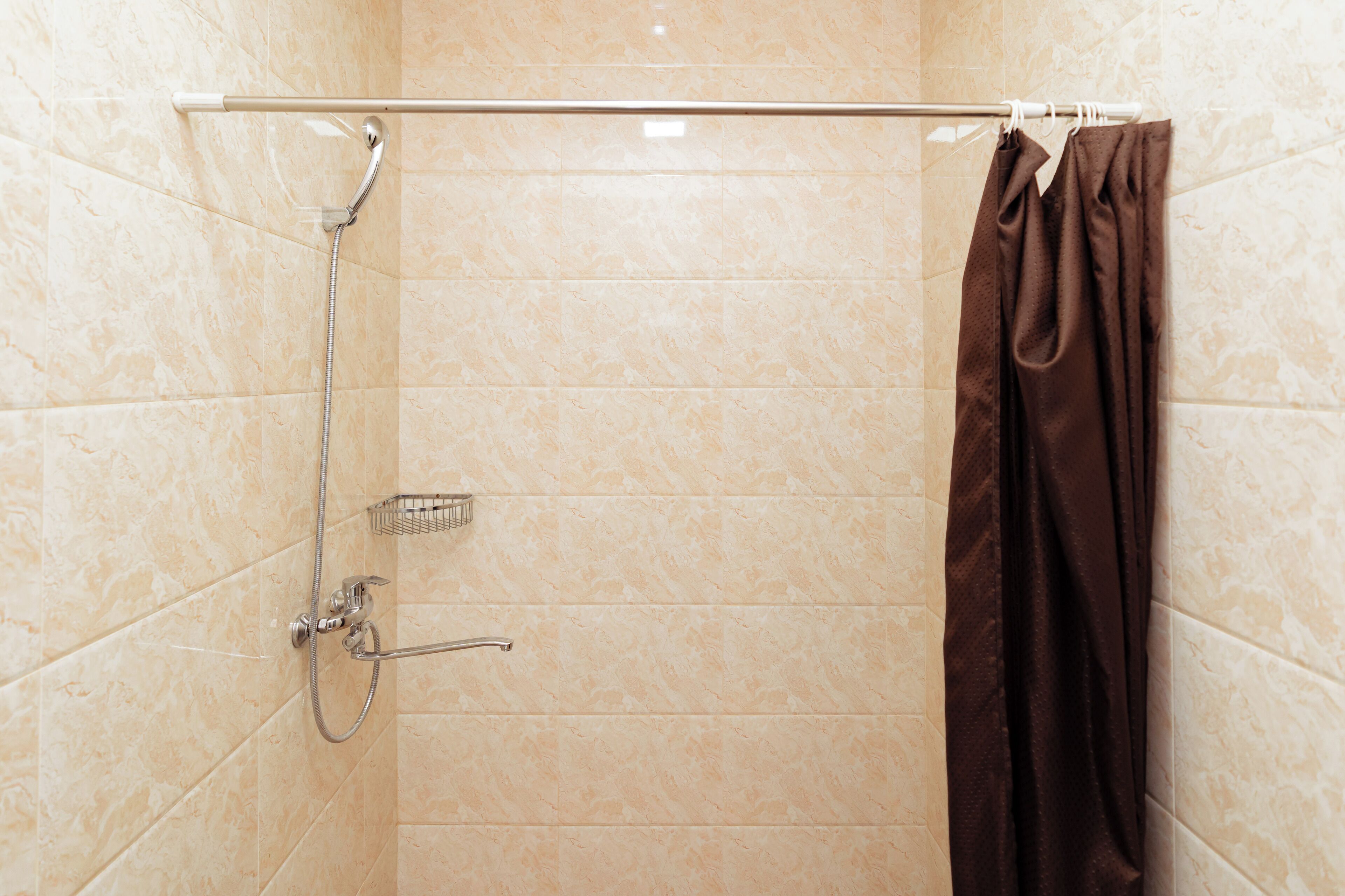 A shower with a glass door, a towel rack, and a showerhead.