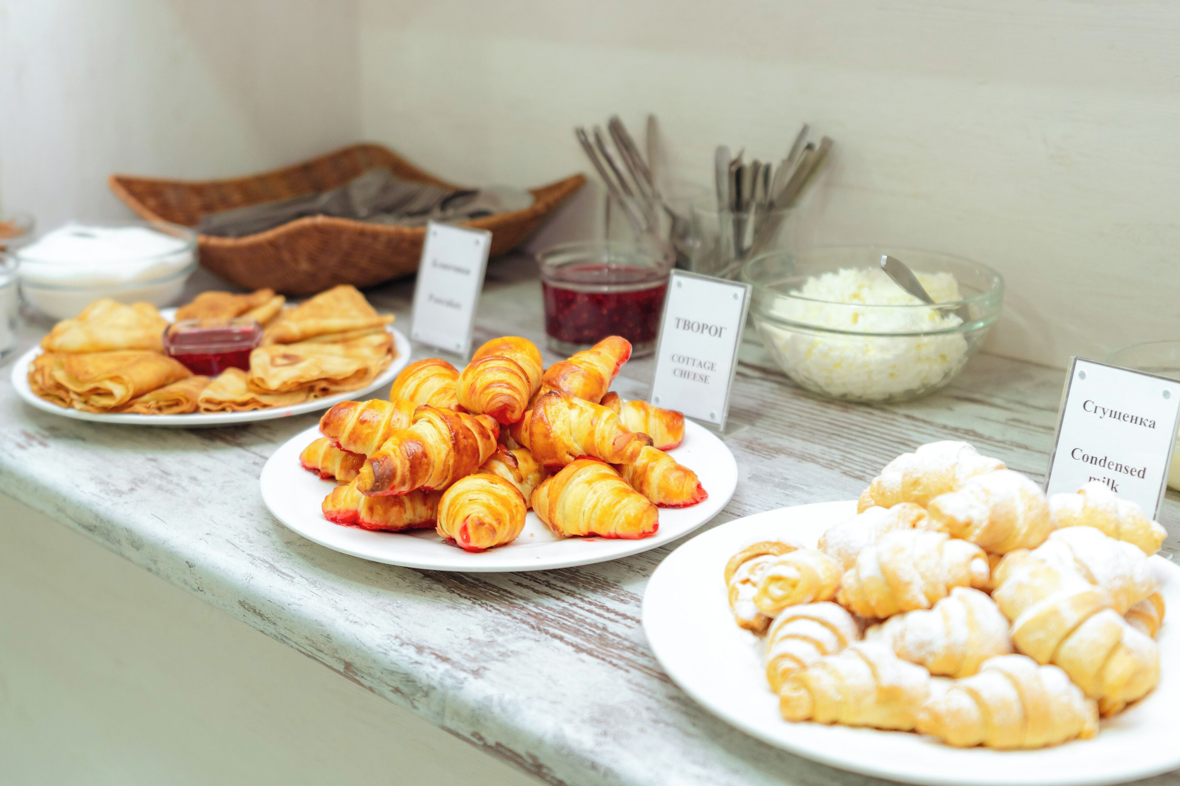 A buffet table with various pastries and condiments.