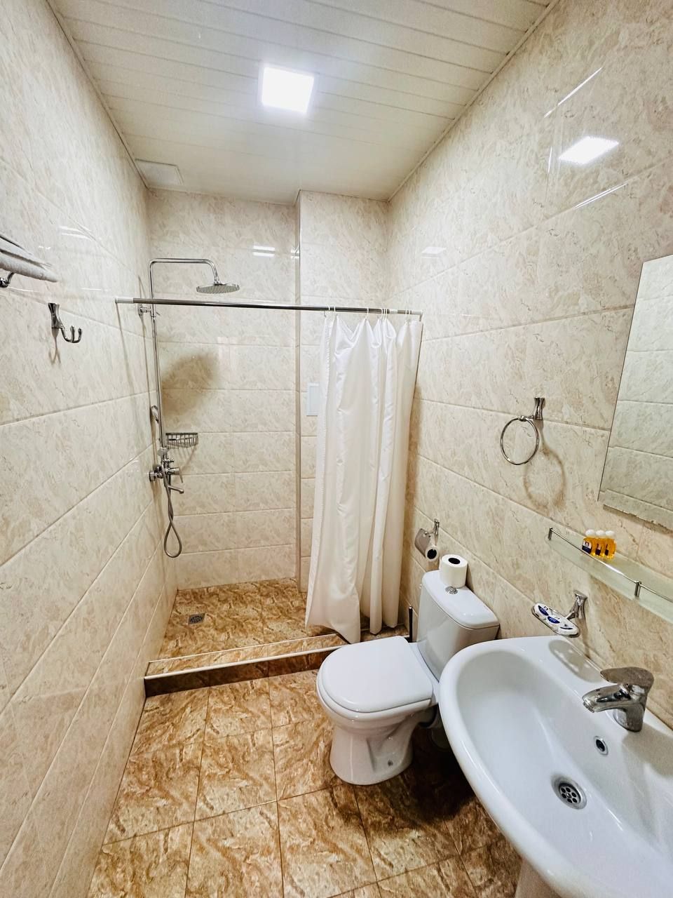 A bathroom with a shower, toilet, and sink.