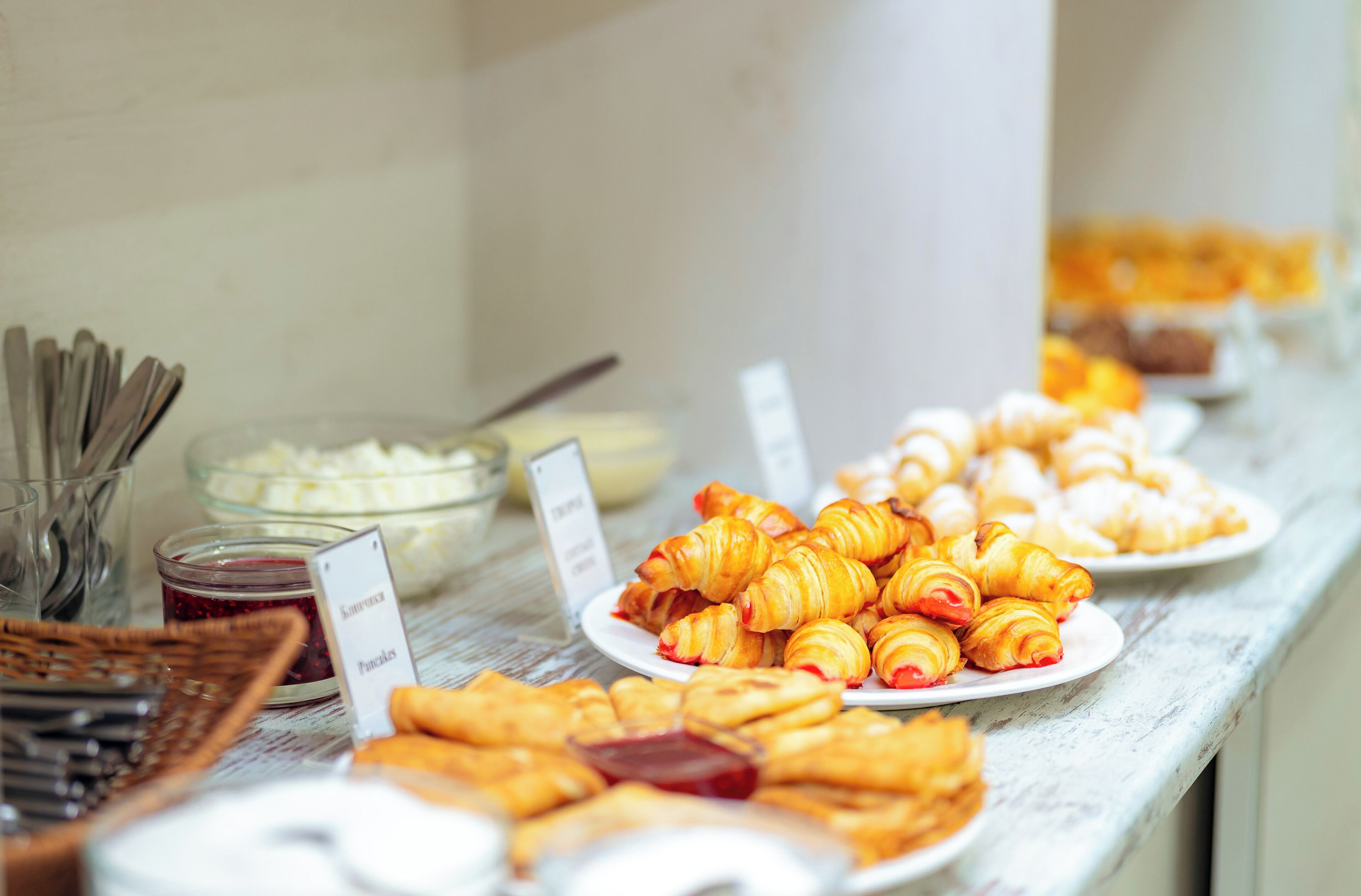 Un bufé con diversos pasteles y un letrero que indica el tipo de comida.