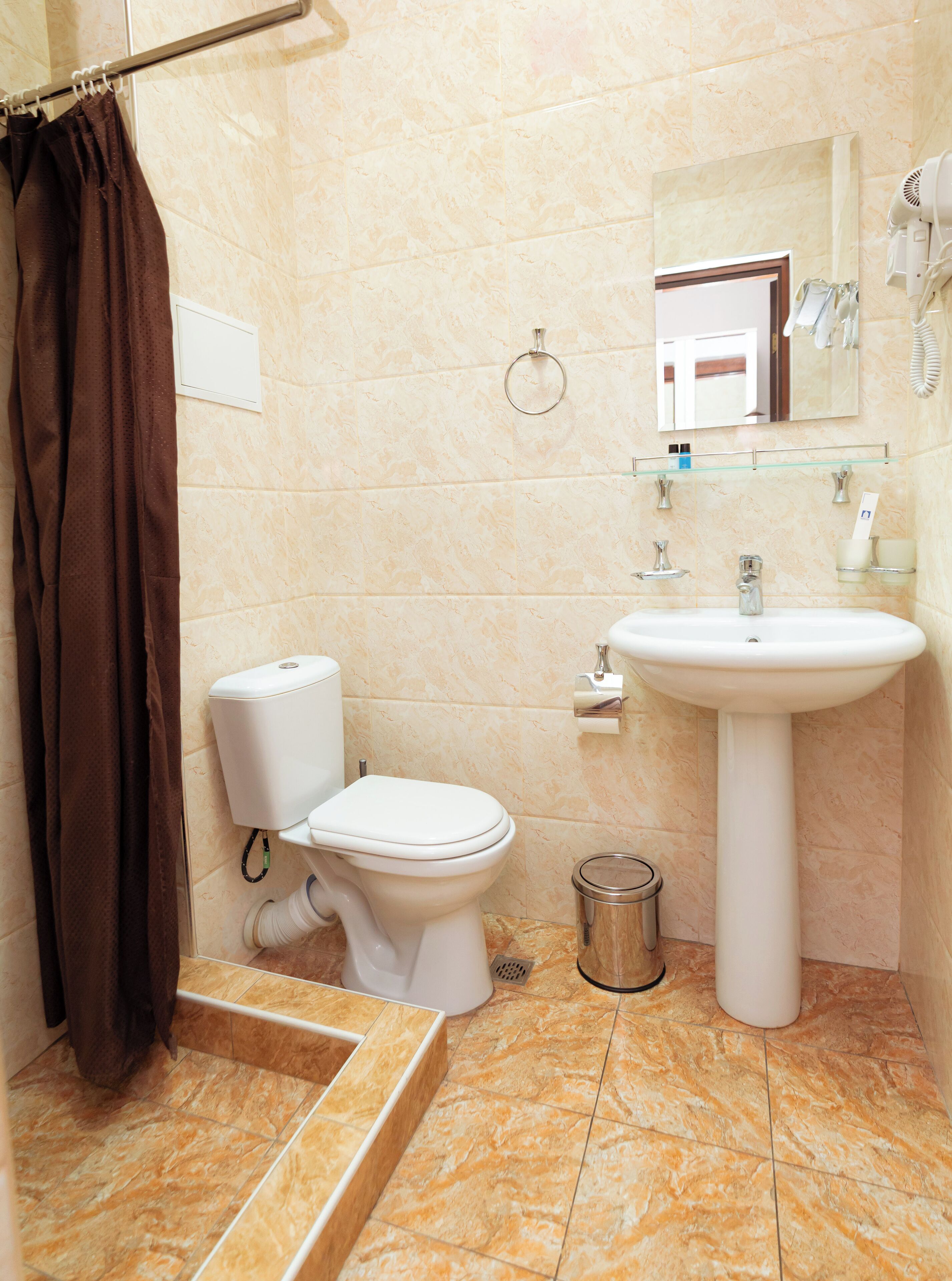 A bathroom with a toilet, sink, and shower curtain.