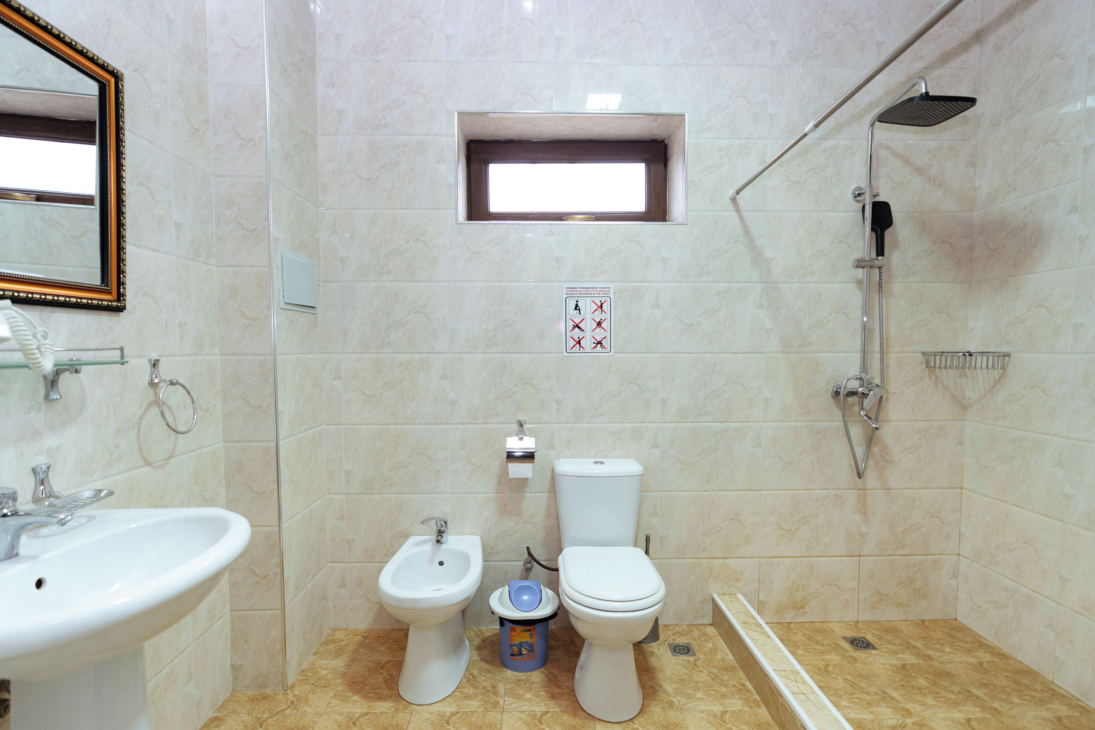 Un baño con bidé, inodoro, lavamanos y ducha.