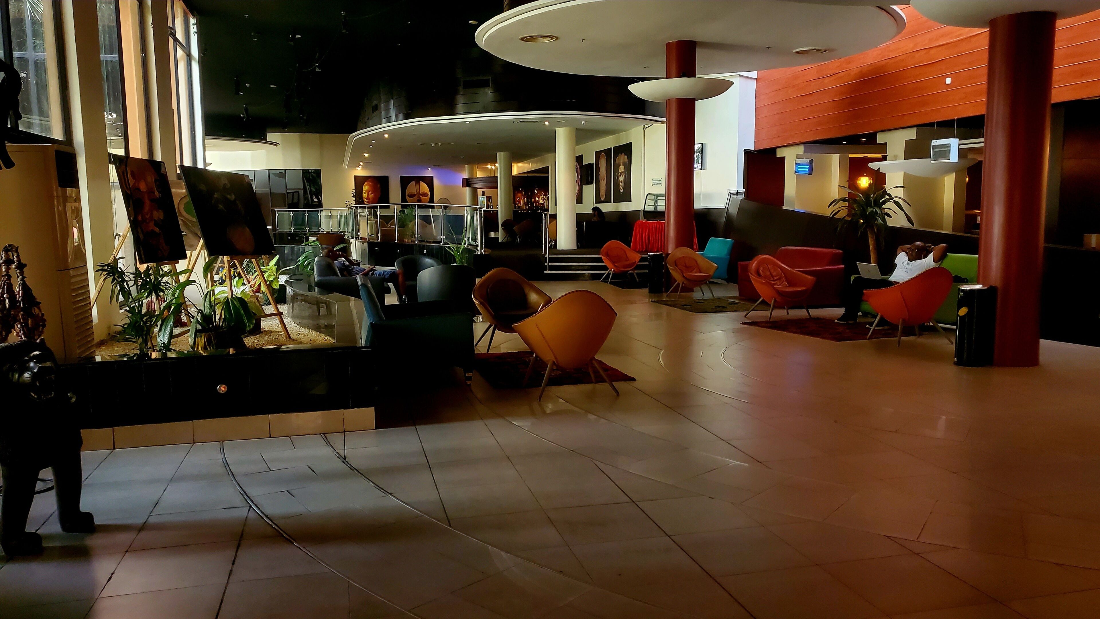 A spacious lobby with modern seating, a reception area, and a display of artwork.