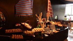 Eine Bäckertheke mit verschiedenen Backwaren, darunter Brot und Gebäck, und ein Schild mit der Aufschrift 'GOLDEN TULIP BAKERY CO.'