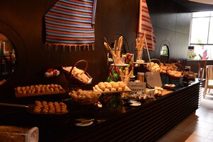 Mostrador de panadería con una variedad de productos horneados, incluyendo pan y pasteles, y un letrero que dice "GOLDEN TULIP BAKERY CO.".