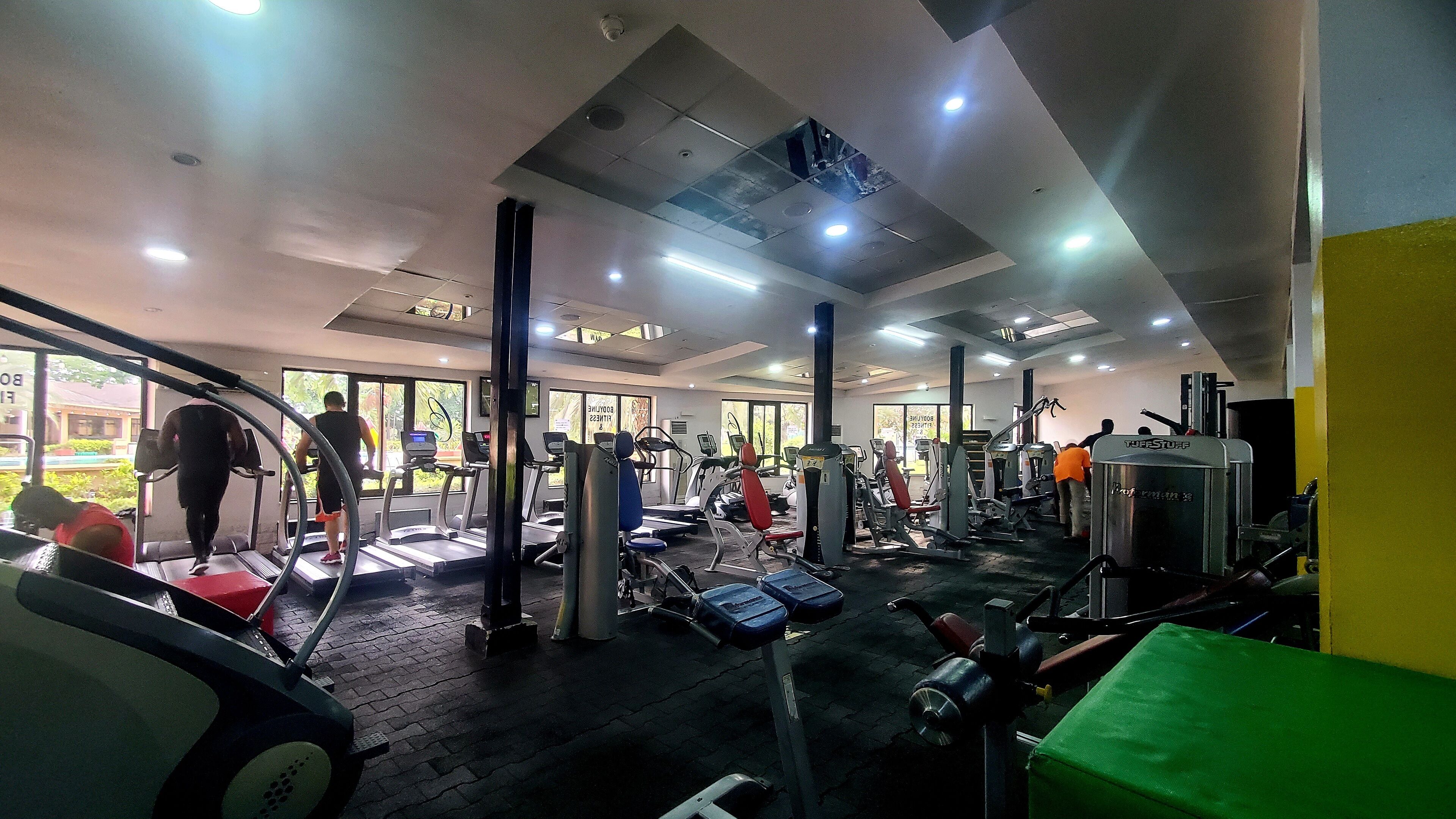 A gym with treadmills, weight machines, and a variety of exercise equipment.