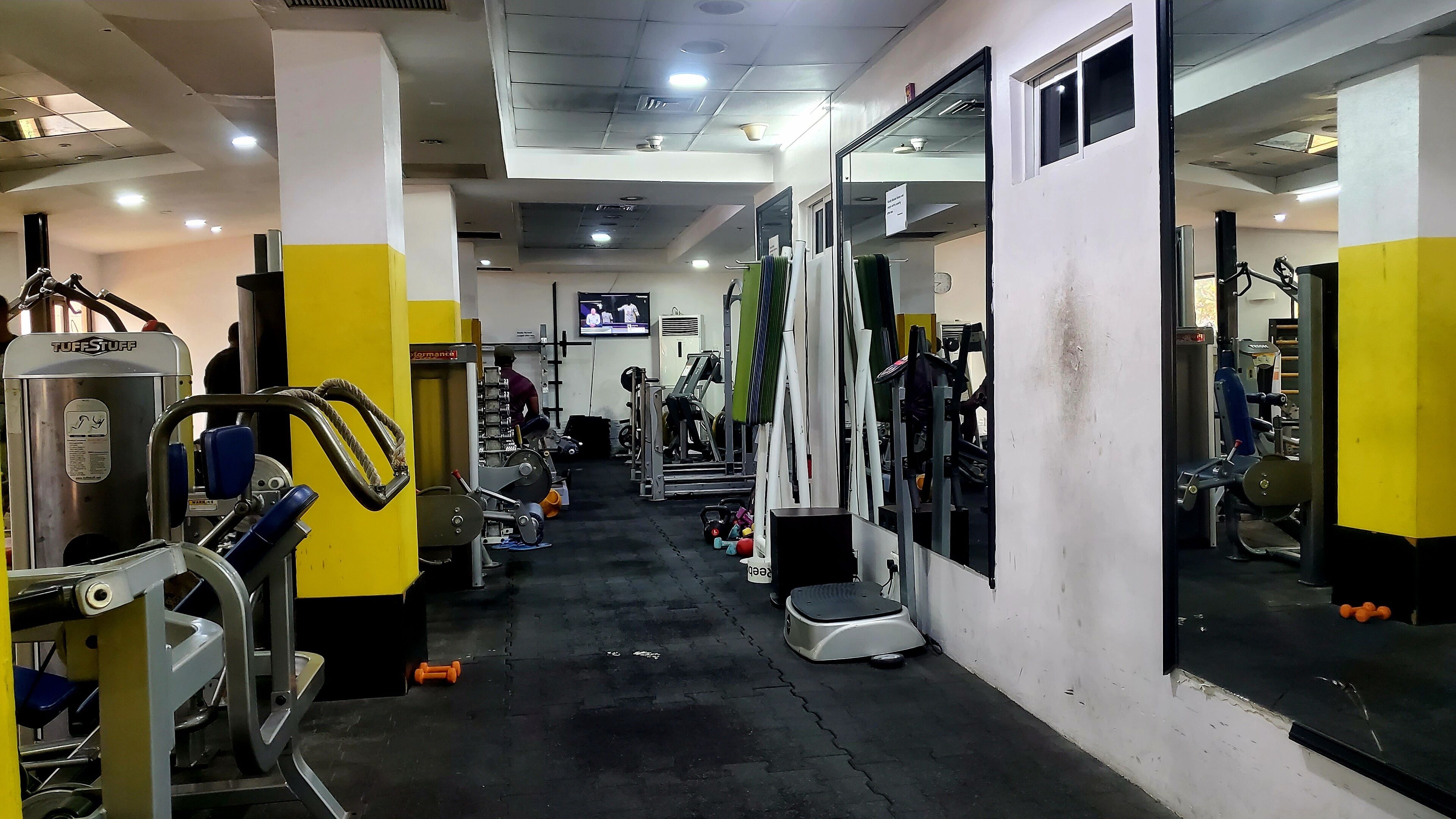 A gym with various exercise equipment, including weight machines and free weights.