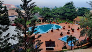 Ein Resort mit Pool, Palmen und Blick auf die Stadt.