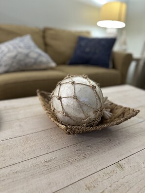 A decorative sphere on a wooden surface with a woven basket. - The White Sand Beaches are calling you (Fort Walton Beach)