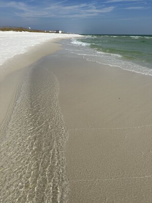 A beach with clear water and a sandy shore.