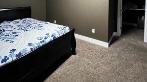 A bedroom with a bed, a closet, and a carpeted floor. - Beautiful 1 bedroom Basement in an Acreage (Delacour)