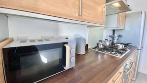 Une cuisine moderne équipée d’un four à micro-ondes, d’une cuisinière et d’un four encastrés.