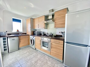 Departamento, varias camas | Cocina privada | Refrigerador, microondas, horno y parrilla de estufa