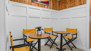 A conference room with a round table, four yellow chairs, and a potted plant. - Pinnacle A11 (Killington)