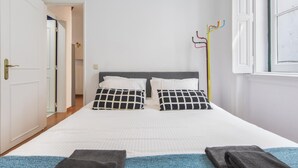A bedroom with a bed, two pillows, a window, and a coat rack. - The Castle Life in Lisboa Ciudad (Lisbon)