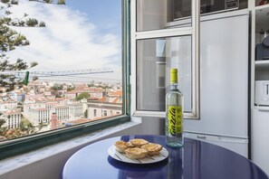 Ein Tisch mit einer Auswahl an Gebäck und einer Flasche Spirituosen, mit Blick auf eine Stadtlandschaft.