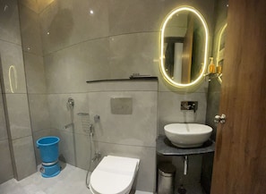Un baño moderno con inodoro, lavamanos y ducha.