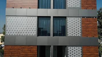 Un edificio moderno con techo plano, múltiples ventanas y un letrero que dice 'LUNAR STAYS'.