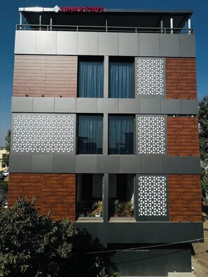 Un edificio moderno con techo plano, múltiples ventanas y un letrero que dice 'LUNAR STAYS'.