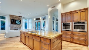 A spacious kitchen with wooden cabinets, a marble island, and built-in ovens. - Scottsdale Vacation Rental w/ Heated Saltwater Pool, Near Kierland, Golf & Spring Training (Scottsdale)