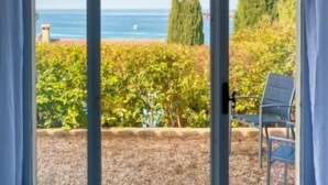 A room with a large circular window offering a view of the sea, a vineyard, and a chair. - La Maison de l'Amiral by Interhome (Sanary sur Mer)