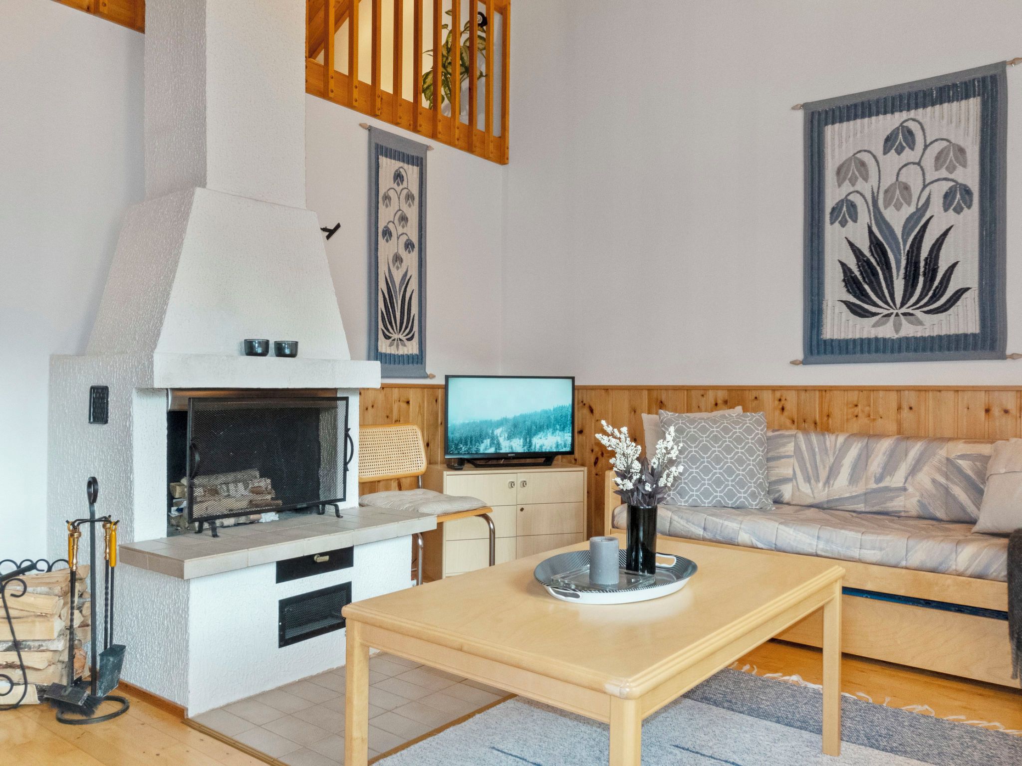 Un salon moderne avec une cheminée, un téléviseur, un canapé et une table basse.