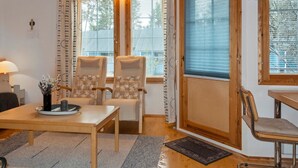 A cozy room with a wooden table, two chairs, a lamp, and a window with blinds. - Siulapalkinen a 4 by Interhome (Inari)