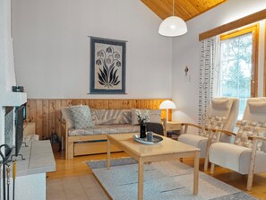 Un salon chaleureux avec un banc en bois, un canapé, une table et une chaise.