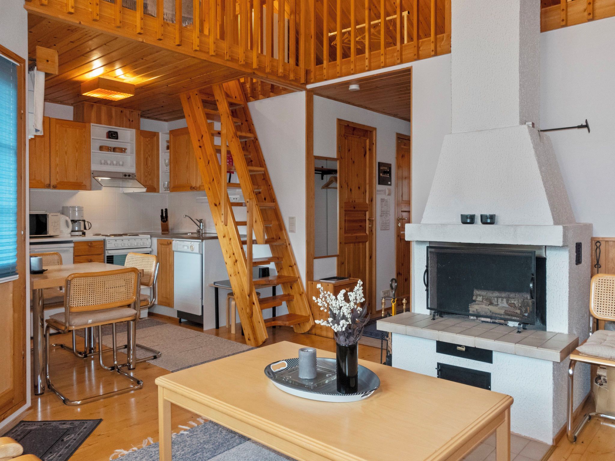 Un interior acogedor con cocina, comedor y chimenea.