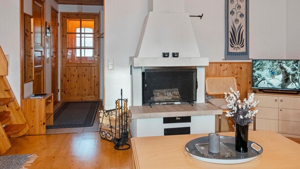 A cozy living room with a fireplace, wooden flooring, and a television. - Siulapalkinen a 4 by Interhome (Inari)