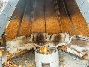 Una chimenea con leña ardiendo dentro de una construcción de piedra.