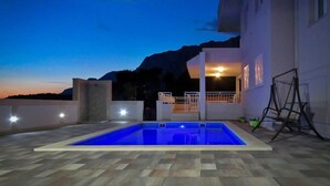Une piscine avec vue sur les montagnes au crépuscule.