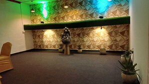 A reception area with a geometric patterned wall, a Buddha statue, and potted plants. - Live Inn Hotel sector 45 (Gurugram)
