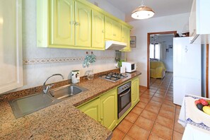 Eine Küche mit Granit-Arbeitsplatten, einem Spülbecken, einem Herd und einem Kühlschrank.