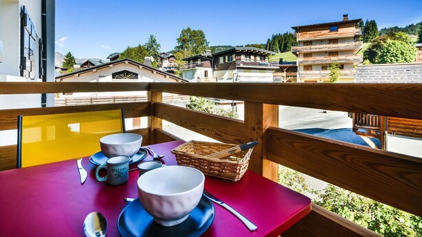A balcony with a red table, white bowls, and a wicker basket. - Stunning Renovated Mountain-Style 2BR+Cabin Apt near Village Center, Sleeps 6 (Les Gets)