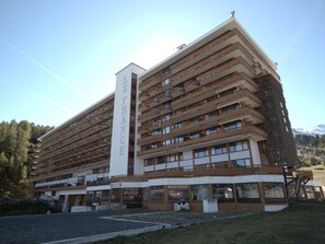 Um hotel com vários andares e uma placa vertical chamativa com a inscrição 