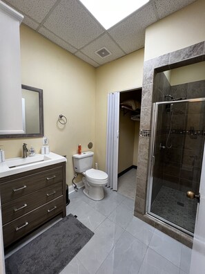 A modern bathroom with a shower, toilet, and vanity. - Very comfortable Loft - free parking - Perimeter UAB (Birmingham)