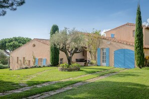 A traditional Mediterranean-style building with a stone pathway leading to the entrance, surrounded by well-maintained greenery and a large tree. - charming villa with stunning view and pool (La Croix-Valmer)