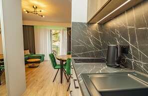 A modern kitchen with a black marble backsplash and a coffee maker on the counter. - Baltic-Apartments - Apartamenty Matejki (Swinoujscie)