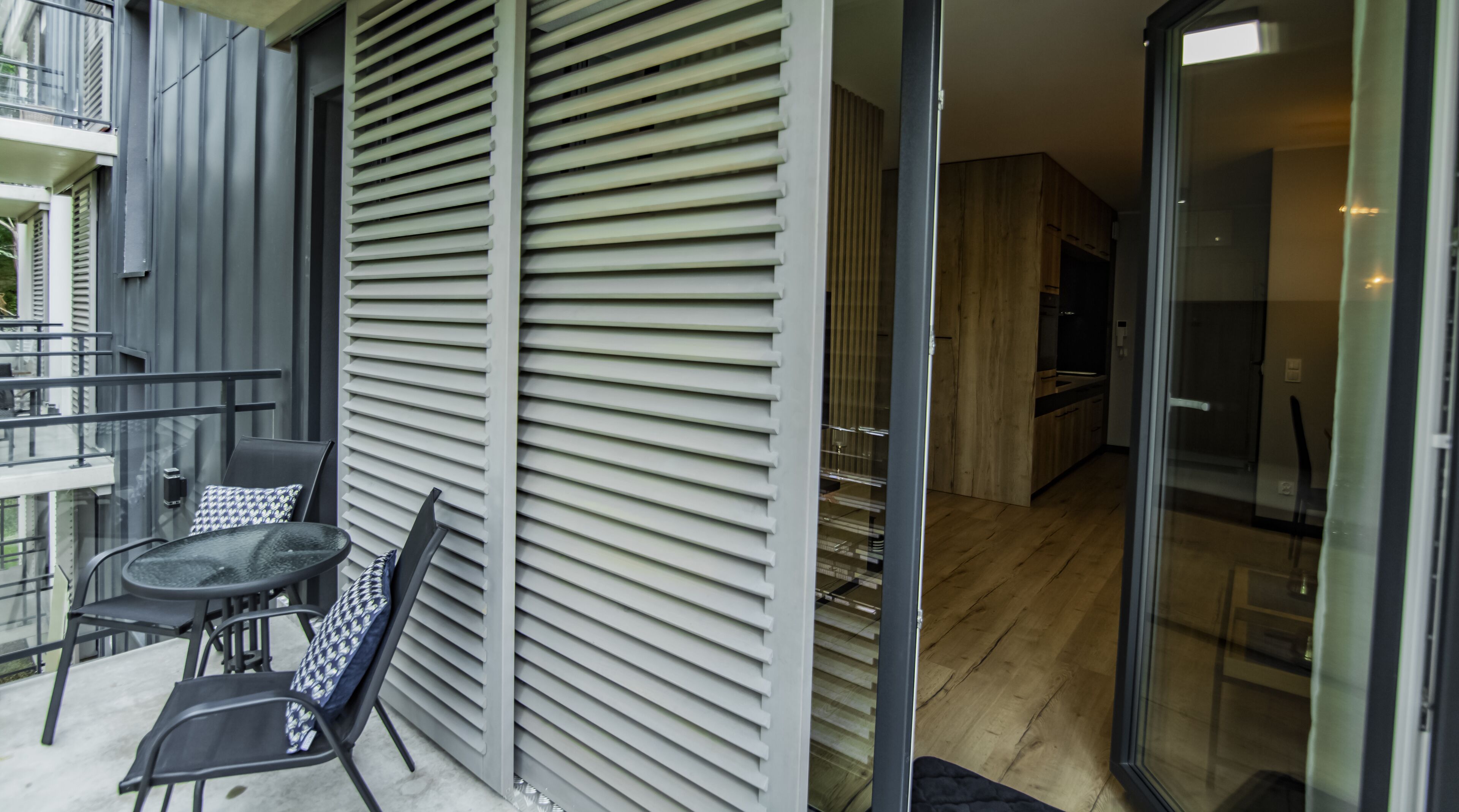 A modern apartment with a balcony, a dining area, and a kitchen.
