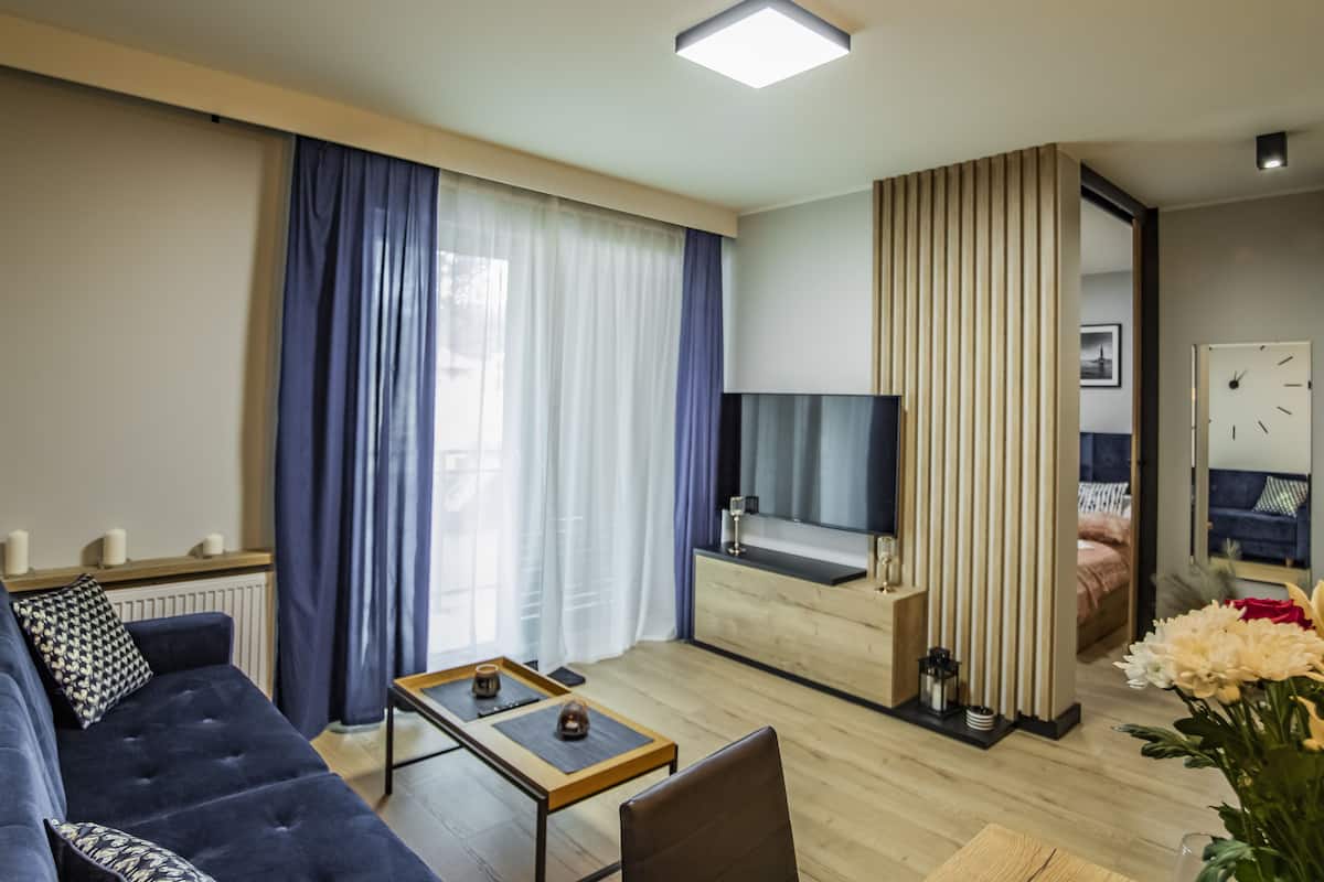 Una sala de estar moderna con un sofá, una mesa de centro y un televisor.
