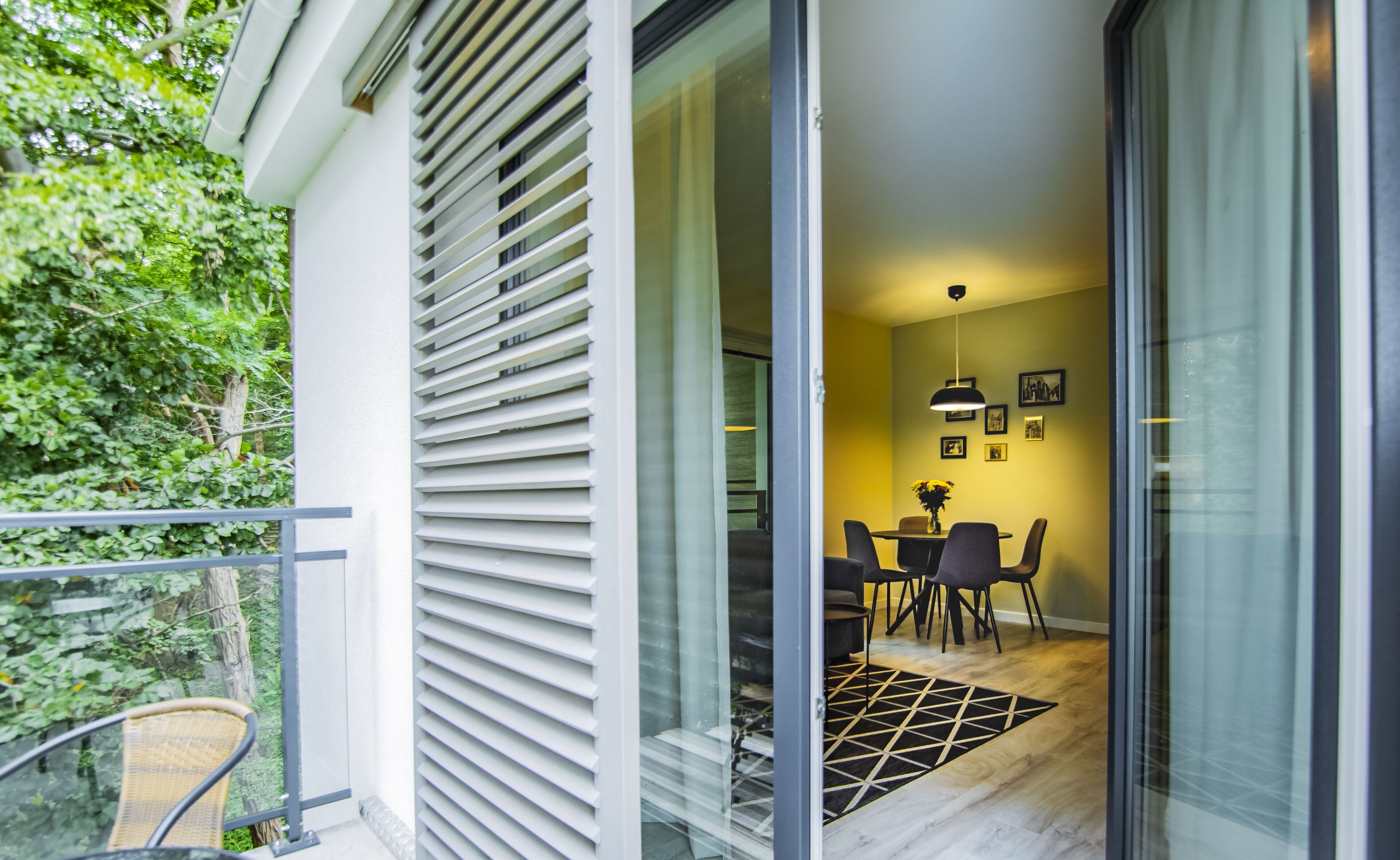 A modern interior with a dining area, a staircase, and a glass door leading outside.