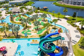 Ein Wasserpark mit großem Pool, Rutschen und Blick auf einen Fluss.