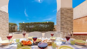 Zona pranzo all'aperto con vista libera sul cielo e un edificio sullo sfondo.