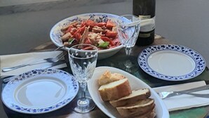 Een tafel met een maaltijd, een fles wijn en uitzicht op het strand.
