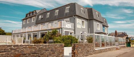 A two-story hotel with a balcony and a glass enclosure.