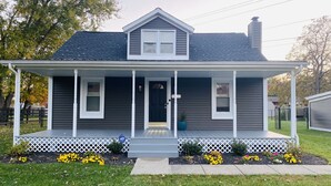 A single-story house with a front porch, a chimney, and a mailbox.
