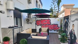 An outdoor seating area with wicker furniture, a water heater, and a mural with graffiti. - Chez Bebel with panoramic pool (Casablanca)