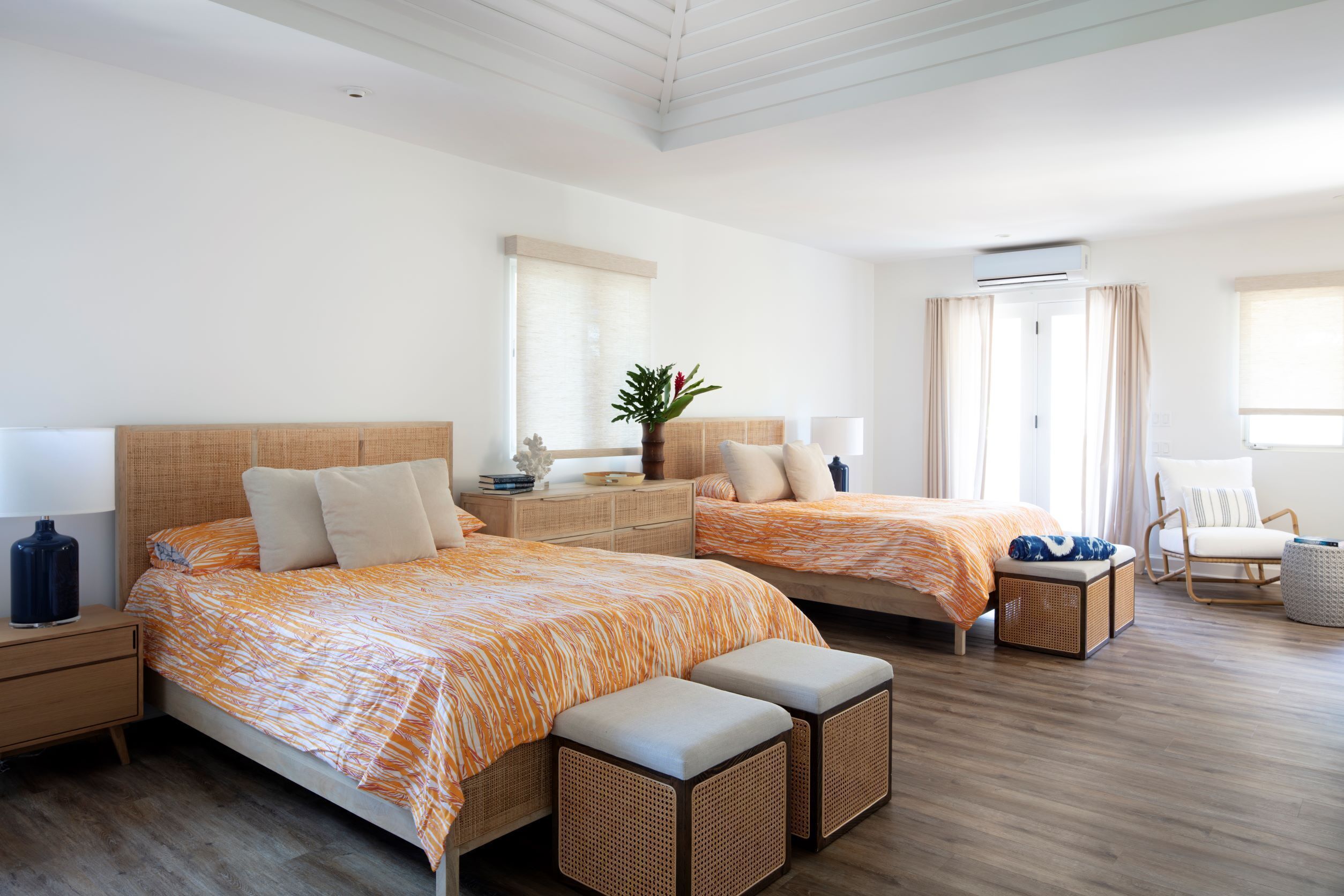 Habitació d'hotel amb dos llits, zona de seients i una finestra gran.